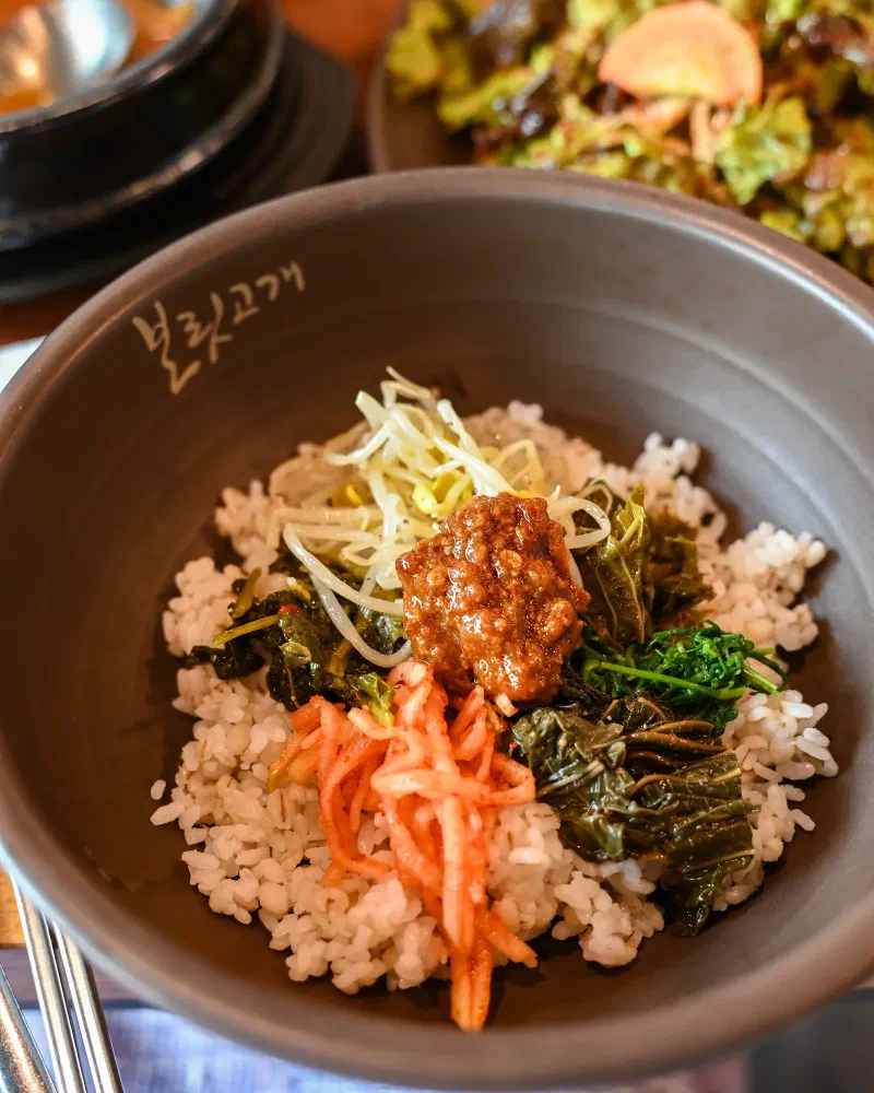 麦飯の上におかずをのせる前の、銀の器に盛られた보리밥のアップ
